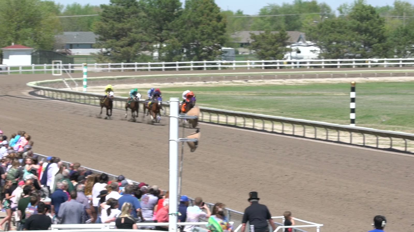 The field comes down the stretch at Fonner Park as the crowd watches from the rail